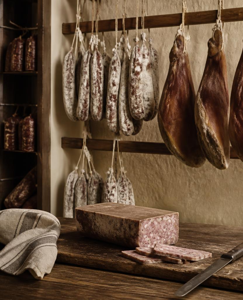Saucissons et jambons suspendus dans l'atelier de charcuterie